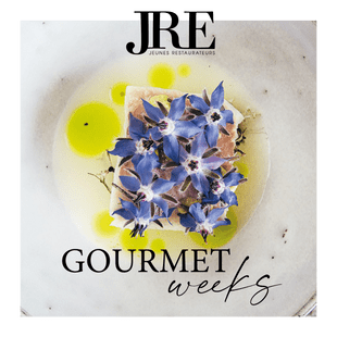 Gourmetgericht mit essbaren blauen Blüten und Kräuteröl für JRE Gourmet Weeks