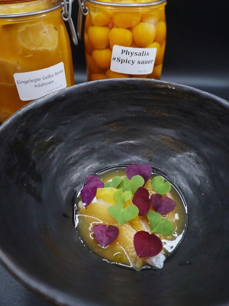 Fisch mit eingelegter gelben Beete und Physalis
