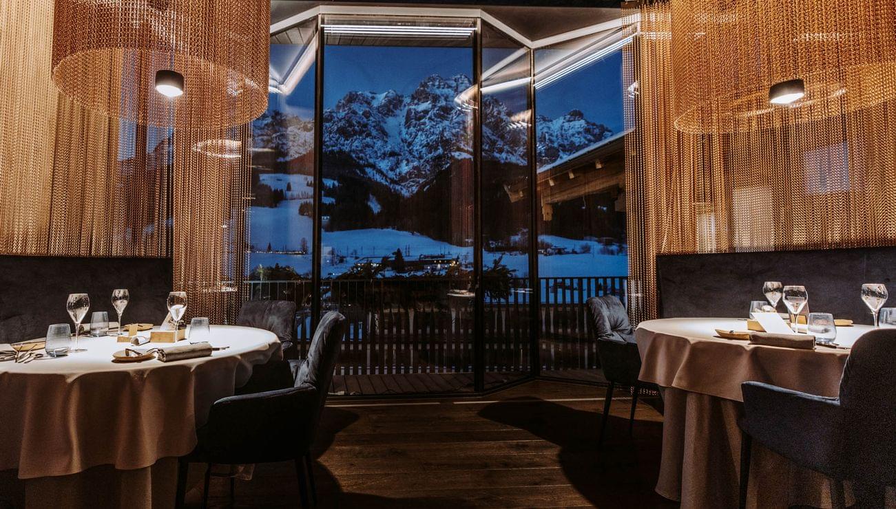 Elegantes Restaurant mit Blick auf schneebedeckte Alpen bei Nacht