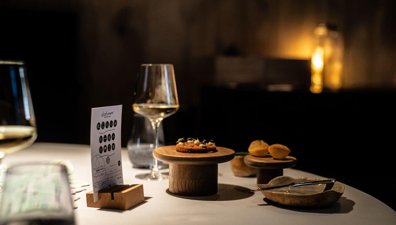 Elegant fine dining table setting with gourmet appetizers and white wine in warm lighting