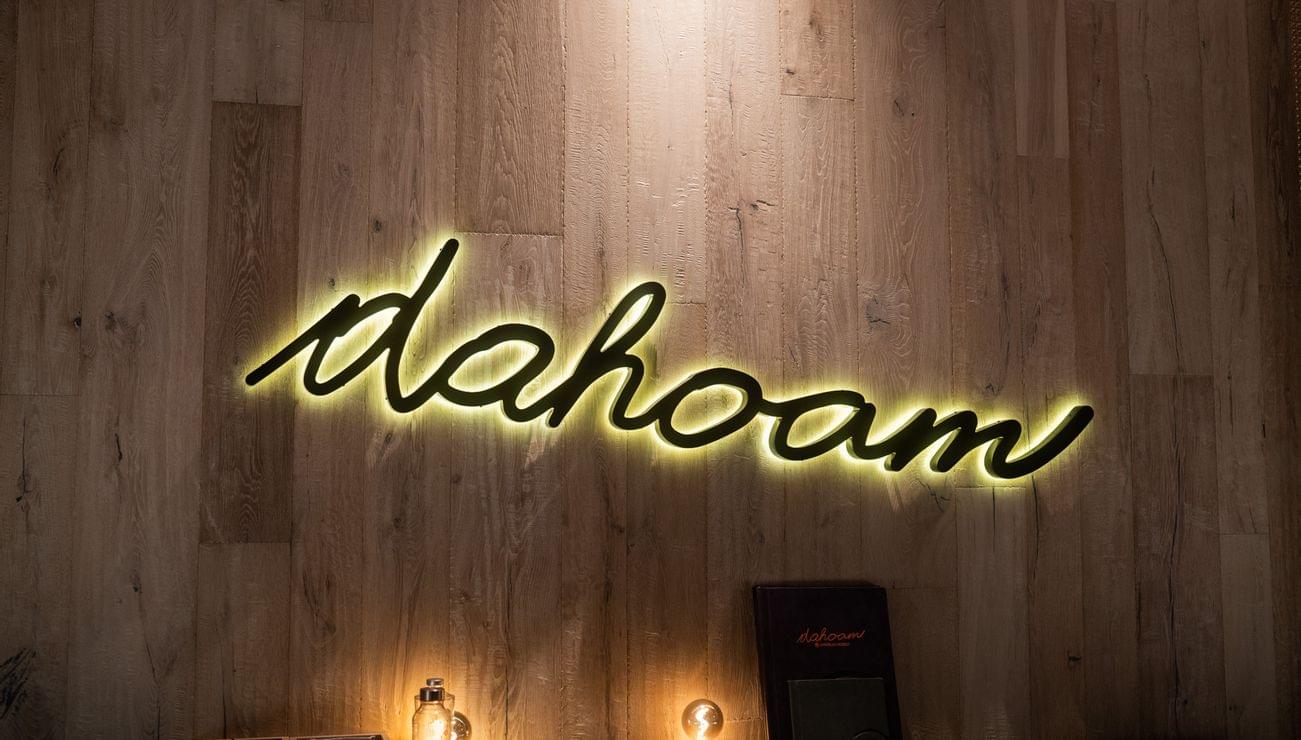Illuminated dahoam sign on wooden wall in cozy restaurant interior